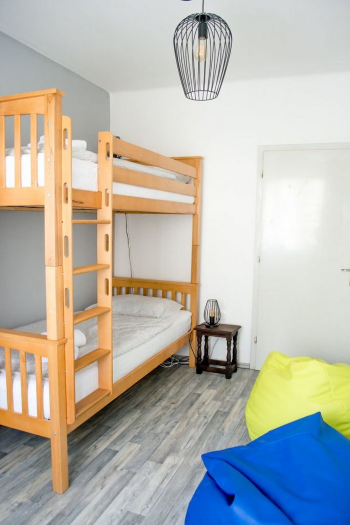 A sleeping room with a bunkbed and colourful teardrop pillows.