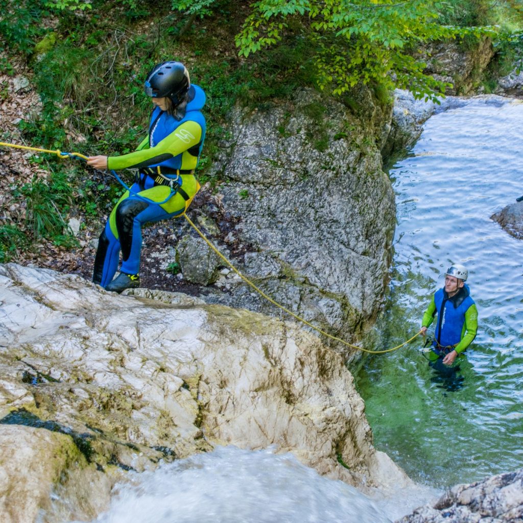 A couple is learning how to abseil while canyoning in Bovec valley.